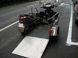 車椅子のまま搭乗可能な、サイドカー？かな？　斬鉄剣で切ったかごとく一刀両断されたスクーターにパワーゲートつきの側車が合体。