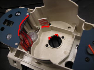 メーターベースを加工します。デジタルメーターがぶつかる部分と配線カプラーを通す為の切り込み（赤ペンで示したあたり）をヤスリやニッパー等で削りとります。
